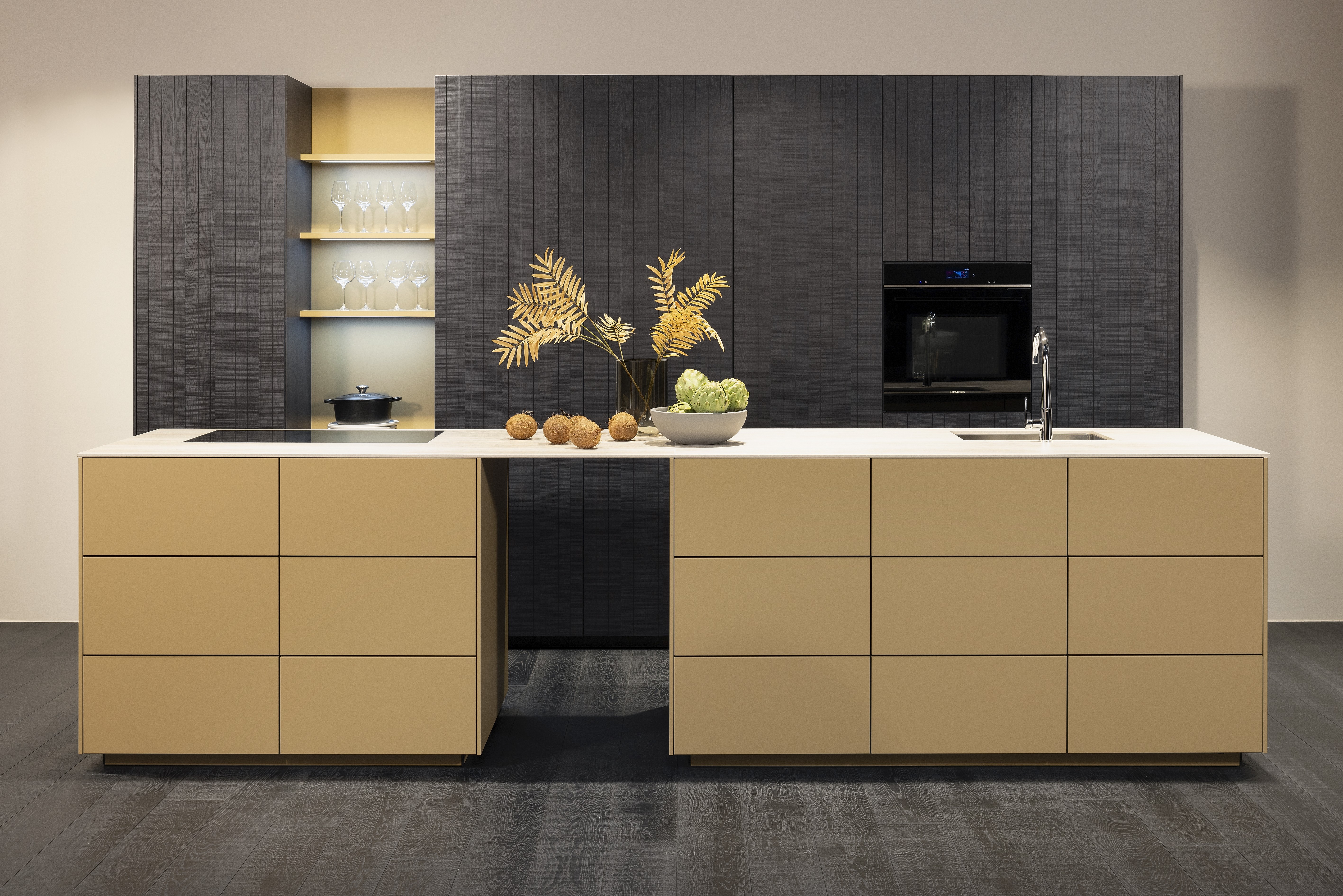 APL: TOP Granit Geo Crema 12 mm Front: SOFT Lack Caramel softmatt Front: neo Chalet Eiche Mokka gerillt  Korpus: Graphit Griff: PTO Geräte: Siemens Armatur: Gesi Spüle: Elleci   Features: Echtholzfront, beleuchtete Regalböden, stringente 60-er Planung, 90-er Höhe mit 30-er Rasterung, Korpus Graphit, Innenbeleuchtung Auszug, Echtholz Fußboden Landhausdielen Schwarz, 12mm Arbeitsplatte in Granit, Arbeitsplatte ohne Schattenfuge aufgesetzt